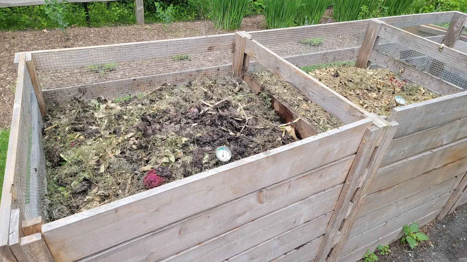 Wooden compost bins filled with soil and garden material